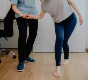 Chiropractor assessing a patient's balance and spinal alignment