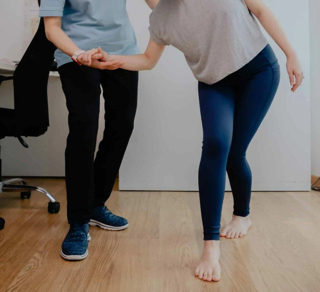Chiropractor assessing a patient's balance and spinal alignment