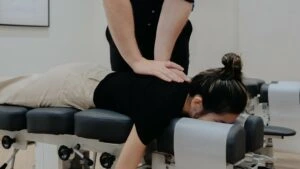 Chiropractor applying a diversified technique adjustment to the spine