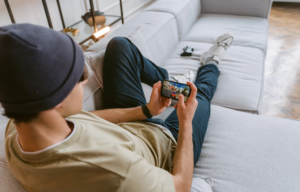 Male gamer playing on a comfortable sofa