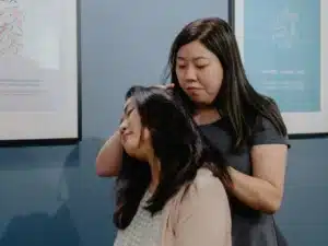 Female practitioner performing a gentle neck stretch for a patient visiting frozen shoulder chiropractors in Singapore.